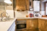 Discover a charming kitchen with rustic wooden cabinets and a modern touch.