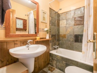 Discover the charm of this bathroom, featuring a stylish pedestal sink and a cozy wooden paneling.
