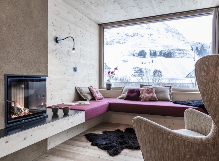 Cozy up in this stunning room with a fireplace and a view of the snowy mountains.