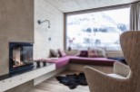 Cozy up in this stunning room with a fireplace and a view of the snowy mountains.