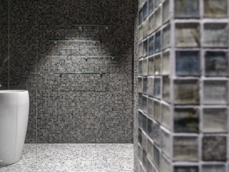 This modern bathroom features a sleek, pedestal sink and a stunning mosaic tile design.
