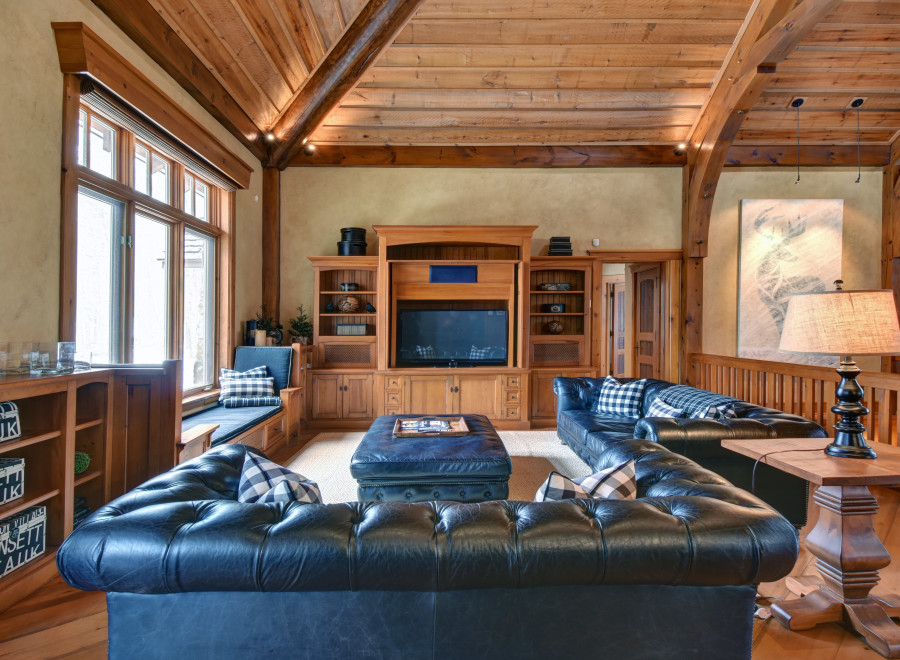 This luxurious living room boasts a rustic charm with its wooden beams and cozy seating.