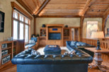This luxurious living room boasts a rustic charm with its wooden beams and cozy seating.