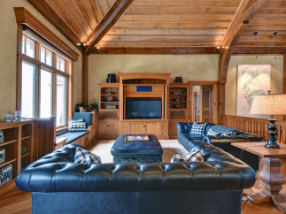 This luxurious living room boasts a rustic charm with its wooden beams and cozy seating.
