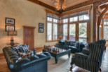 This luxurious living room boasts a cozy ambiance with its wooden ceiling and large windows.