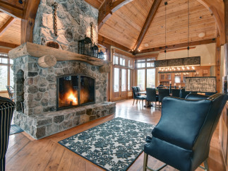 Experience rustic elegance in this stunning home featuring a grand stone fireplace, perfect for cozy evenings.