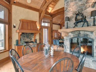 This stunning property boasts a rustic charm with its exposed wooden beams and stone fireplace.