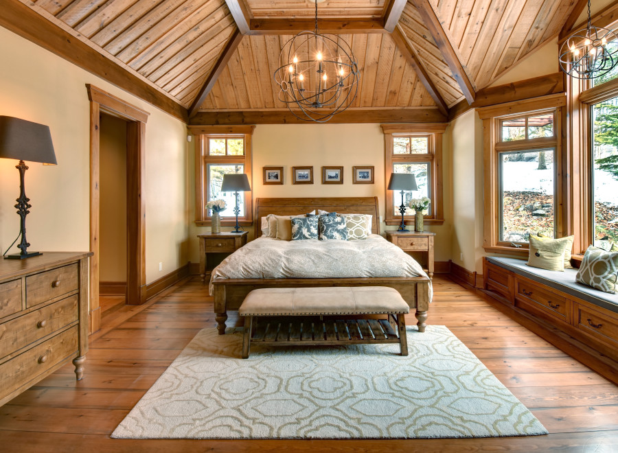 This stunning bedroom boasts a rustic charm with its wooden vaulted ceiling and warm, inviting ambiance.