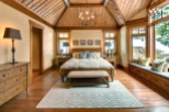 This stunning bedroom boasts a rustic charm with its wooden vaulted ceiling and warm, inviting ambiance.