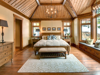 This stunning bedroom boasts a rustic charm with its wooden vaulted ceiling and warm, inviting ambiance.