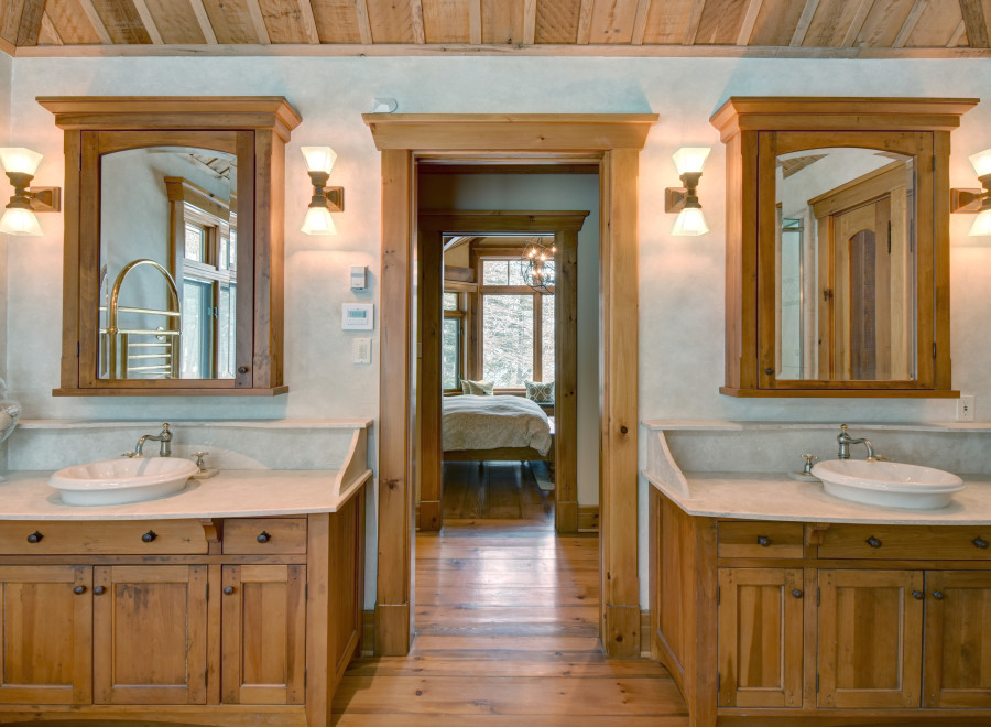 This luxurious bathroom features custom wooden cabinetry and a stunning marble countertop, creating a warm and inviting atmosphere.