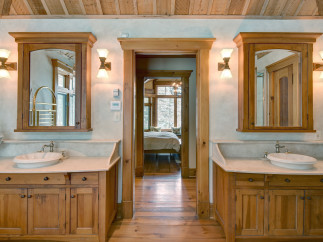 This luxurious bathroom features custom wooden cabinetry and a stunning marble countertop, creating a warm and inviting atmosphere.