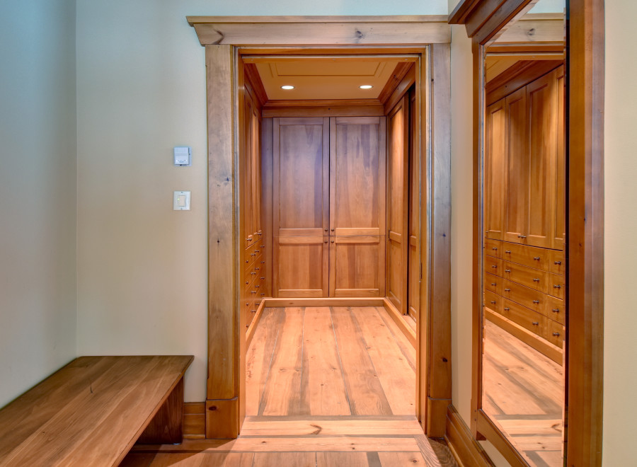 Step into luxury with this stunning walk-in closet, featuring custom wooden cabinetry and ample storage space.
