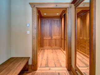 Step into luxury with this stunning walk-in closet, featuring custom wooden cabinetry and ample storage space.