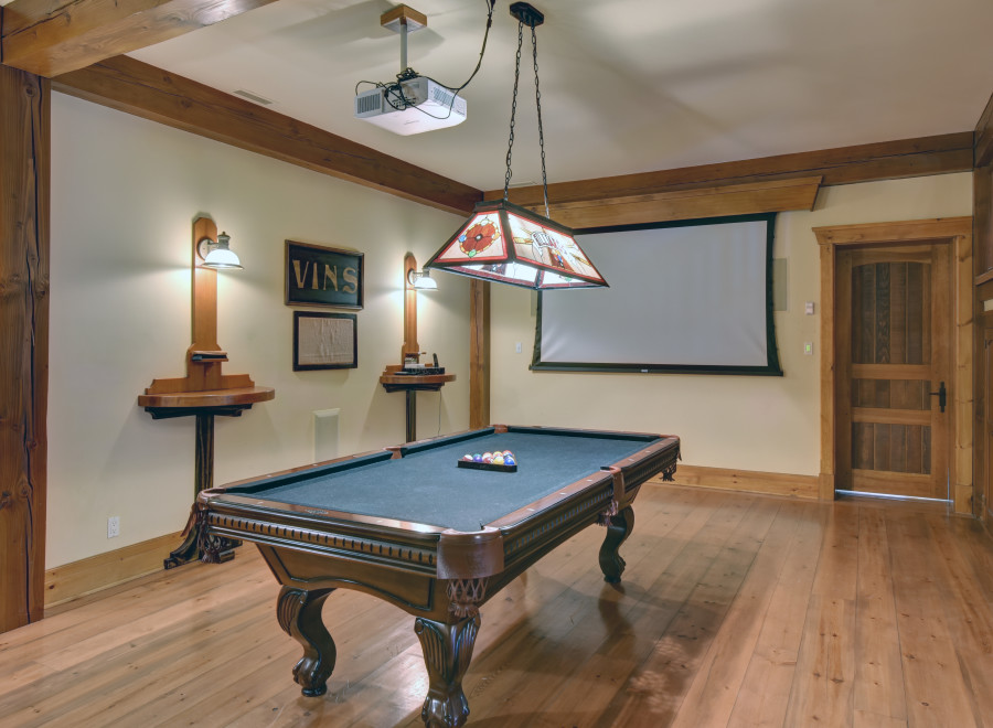 Step into a luxurious game room featuring a stunning pool table and a large projection screen, perfect for entertainment.