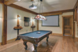 Step into a luxurious game room featuring a stunning pool table and a large projection screen, perfect for entertainment.