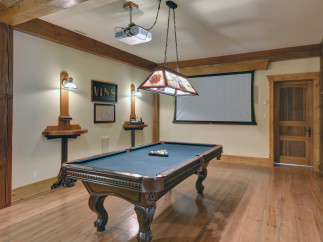 Step into a luxurious game room featuring a stunning pool table and a large projection screen, perfect for entertainment.
