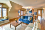 This stunning living space boasts a cozy ambiance with its plush blue sofa and inviting seating arrangement.