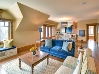 This stunning living space boasts a cozy ambiance with its plush blue sofa and inviting seating arrangement.