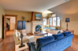 This cozy living room features a beautiful fireplace and a comfortable blue velvet sofa, perfect for relaxing.
