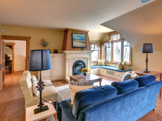 This cozy living room features a beautiful fireplace and a comfortable blue velvet sofa, perfect for relaxing.
