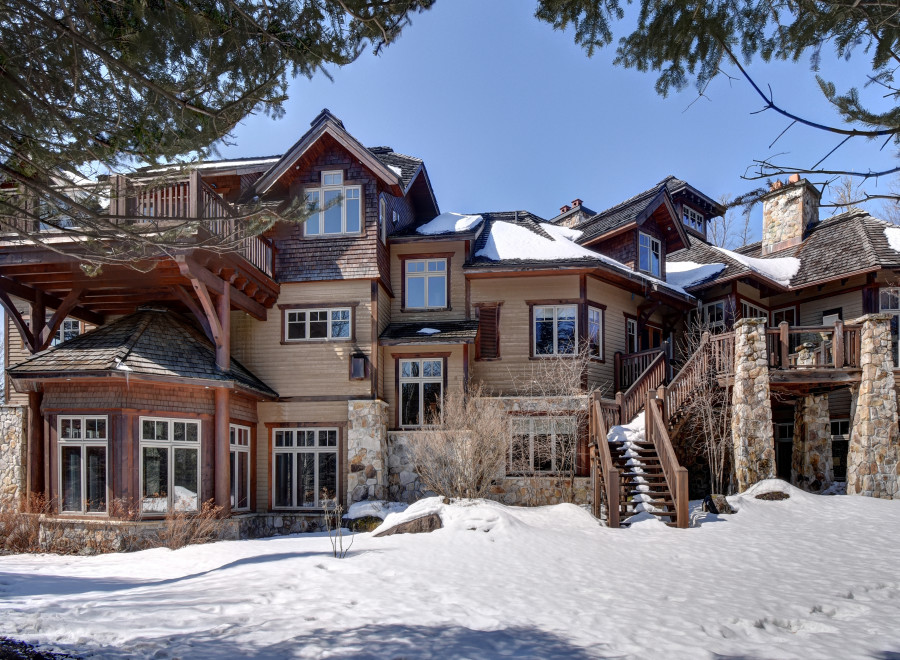 This stunning mountain home boasts a unique architectural design with a blend of wood and stone elements.