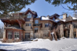 This stunning mountain home boasts a unique architectural design with a blend of wood and stone elements.