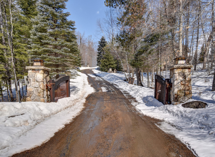 A picturesque winter scene unfolds at the entrance of this stunning property.