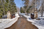A picturesque winter scene unfolds at the entrance of this stunning property.