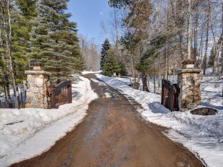 A picturesque winter scene unfolds at the entrance of this stunning property.