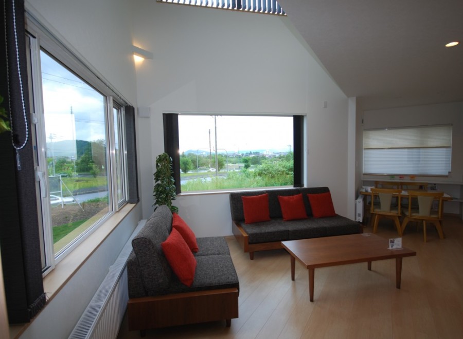 This modern living space boasts a bright and airy atmosphere with its large windows and high ceilings.
