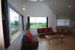 This modern living space boasts a bright and airy atmosphere with its large windows and high ceilings.
