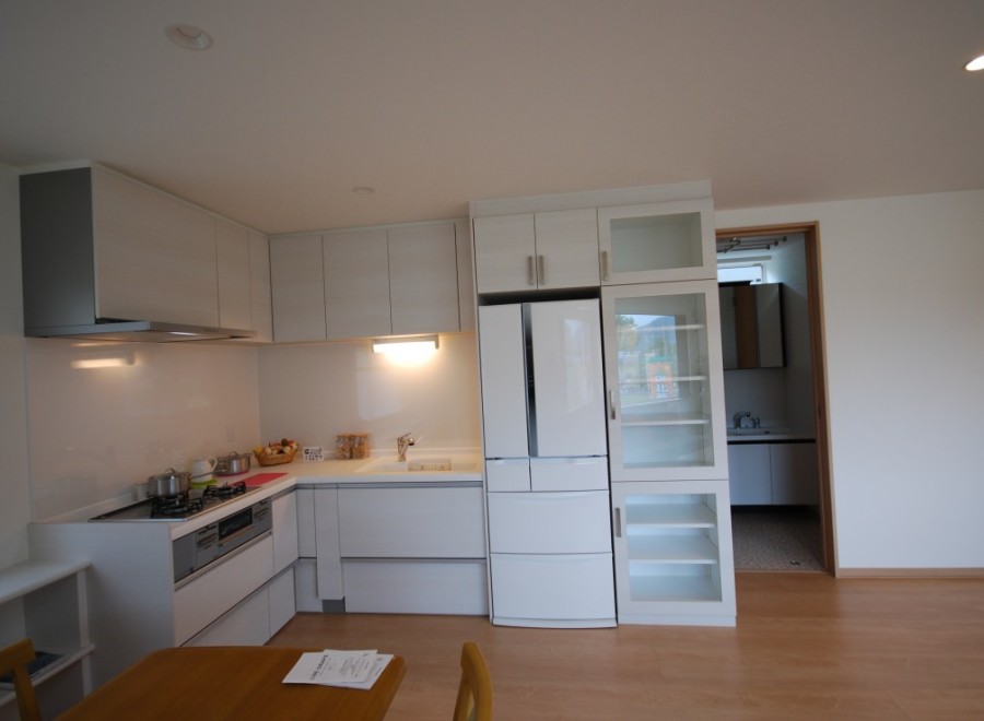 This modern kitchen boasts sleek white cabinetry and appliances, creating a bright and inviting space.