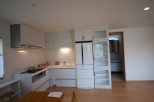 This modern kitchen boasts sleek white cabinetry and appliances, creating a bright and inviting space.