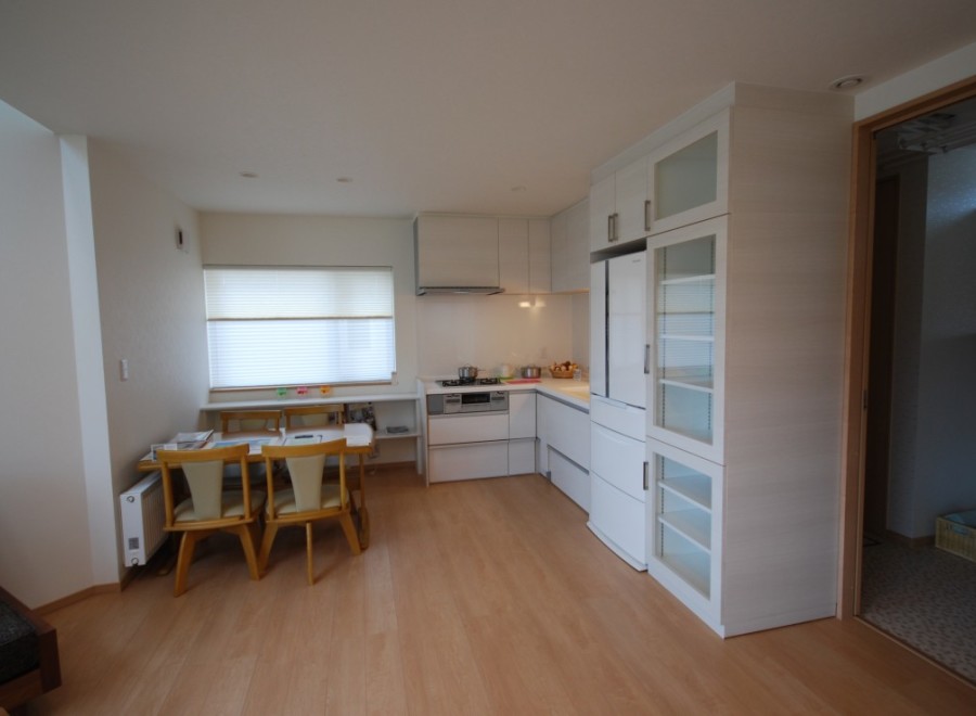 This bright and airy kitchen features modern white cabinetry and appliances, creating a clean and inviting space.