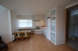 This bright and airy kitchen features modern white cabinetry and appliances, creating a clean and inviting space.