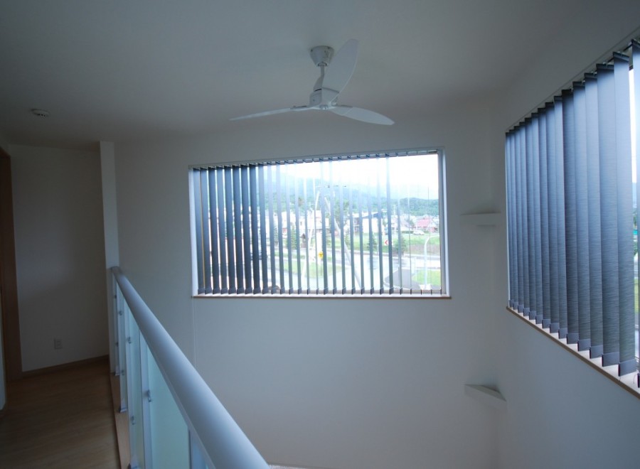 Discover a bright and airy interior with a modern ceiling fan and large windows.