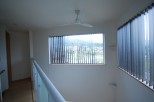 Discover a bright and airy interior with a modern ceiling fan and large windows.