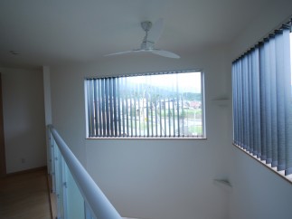 Discover a bright and airy interior with a modern ceiling fan and large windows.