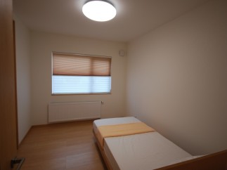 Cozy bedroom with natural light and a comfortable bed.