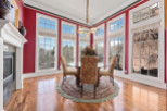 This elegant dining room boasts a stunning array of windows, offering panoramic views and abundant natural light.