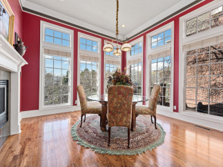 This elegant dining room boasts a stunning array of windows, offering panoramic views and abundant natural light.