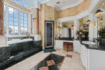 Indulge in luxury within this exquisite bathroom, featuring a stunning marble tub and countertops.