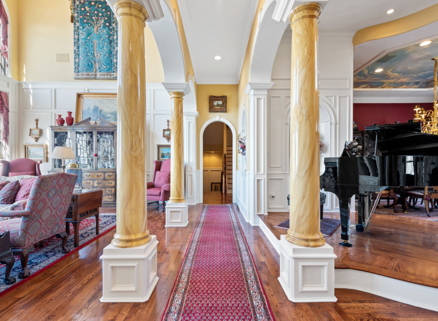 Step into luxury with this stunning property featuring elegant columns and a grand piano.