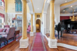 Step into luxury with this stunning property featuring elegant columns and a grand piano.
