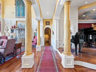 Step into luxury with this stunning property featuring elegant columns and a grand piano.