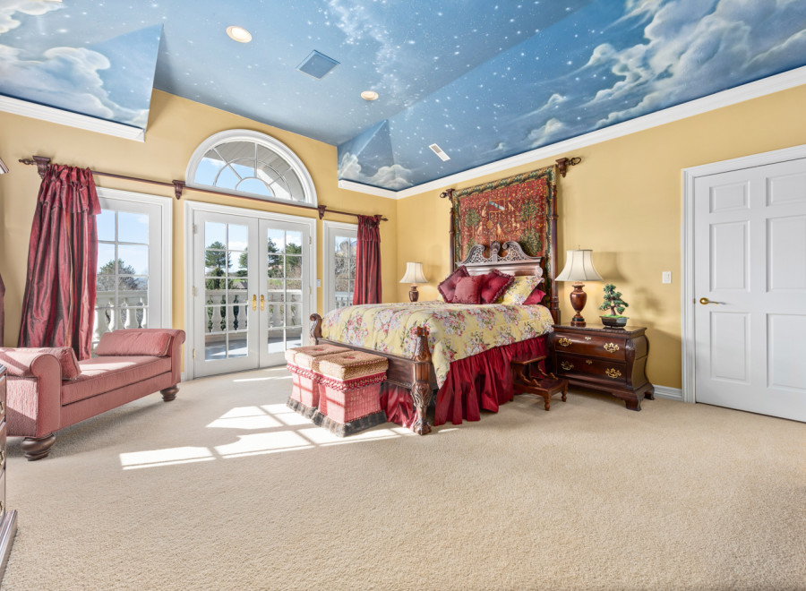 Step into a luxurious bedroom with a whimsical sky-painted ceiling, creating a serene and dreamy atmosphere.