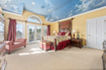 Step into a luxurious bedroom with a whimsical sky-painted ceiling, creating a serene and dreamy atmosphere.