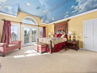 Step into a luxurious bedroom with a whimsical sky-painted ceiling, creating a serene and dreamy atmosphere.
