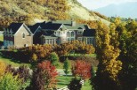 This stunning property showcases a grand brick mansion nestled amidst a vibrant autumn landscape.